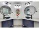 Modern bathroom with dual sinks, dark blue cabinets, gold hardware and unique faucets at 3241 Evening Breeze Loop, Wesley Chapel, FL 33544