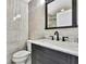 Modern bathroom featuring gray tile walls, a dark vanity, and a large mirror at 3241 Evening Breeze Loop, Wesley Chapel, FL 33544