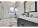 Elegant bathroom featuring a marble countertop, gray tile, oval window, and a shower-over-tub with glass door at 3241 Evening Breeze Loop, Wesley Chapel, FL 33544