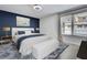 This bedroom features a blue accent wall, a ceiling fan, and a window with natural light at 3241 Evening Breeze Loop, Wesley Chapel, FL 33544