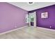 Bedroom with purple walls, white trim, and light laminate flooring at 3241 Evening Breeze Loop, Wesley Chapel, FL 33544