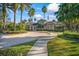 Community clubhouse with palm trees and landscaped grounds, showcasing a welcoming entrance at 3241 Evening Breeze Loop, Wesley Chapel, FL 33544