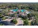 Stunning aerial view of the community pool and recreation center surrounded by lush palm trees at 3241 Evening Breeze Loop, Wesley Chapel, FL 33544