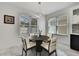 Bright dining area with a round table, four chairs, and natural light from large windows at 3241 Evening Breeze Loop, Wesley Chapel, FL 33544