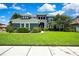 Beautiful two-story home with a lush green lawn and manicured landscaping at 3241 Evening Breeze Loop, Wesley Chapel, FL 33544