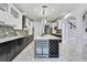 Bright kitchen boasts a large island with seating, wine cooler, white cabinets, and modern stainless steel appliances at 3241 Evening Breeze Loop, Wesley Chapel, FL 33544