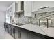 Stylish kitchen with sleek black cabinets, white countertops, stainless steel hood, and mosaic tile backsplash at 3241 Evening Breeze Loop, Wesley Chapel, FL 33544
