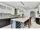 Spacious kitchen features a large island with seating, wine cooler, quartz countertops, and stylish backsplash at 3241 Evening Breeze Loop, Wesley Chapel, FL 33544