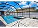 Stunning pool and spa within screened lanai, surrounded by white fence and lush landscaping at 3241 Evening Breeze Loop, Wesley Chapel, FL 33544