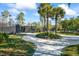 View of the community tennis court, surrounded by landscaping and trees, in the sunshine at 3241 Evening Breeze Loop, Wesley Chapel, FL 33544