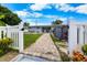 Inviting backyard with a brick path leading to a patio, surrounded by lush greenery and a barbecue area at 3260 Gulfview Dr, Hernando Beach, FL 34607