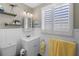 Bathroom with white vanity, yellow towels, and shelves holding decorative items at 3260 Gulfview Dr, Hernando Beach, FL 34607