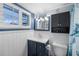 Bathroom features a navy vanity, toilet, white wall paneling, and a shuttered window at 3260 Gulfview Dr, Hernando Beach, FL 34607