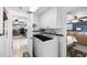 A laundry area with a front-load washer and dryer and a view of the kitchen and bedroom at 3260 Gulfview Dr, Hernando Beach, FL 34607