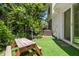 Backyard with artificial grass, a picnic table, a grill and lush landscaping near the home's exterior at 3323 Fox Hunt Dr, Palm Harbor, FL 34683