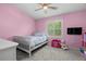 Pink bedroom with a bed, toy box, and window at 3323 Fox Hunt Dr, Palm Harbor, FL 34683
