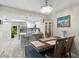 Open concept kitchen and dining room with modern light fixtures and wood-look floors at 3323 Fox Hunt Dr, Palm Harbor, FL 34683