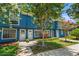 Inviting blue townhome showing the front entrance with lovely flowering trees and landscaping at 3323 Fox Hunt Dr, Palm Harbor, FL 34683
