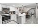 Modern kitchen with stainless steel appliances, white cabinets, gray backsplash, and marble countertops at 3323 Fox Hunt Dr, Palm Harbor, FL 34683
