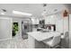 Bright kitchen with stainless steel appliances, white cabinets, marble counters, and a view to the backyard at 3323 Fox Hunt Dr, Palm Harbor, FL 34683
