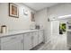 Bright kitchenette space featuring white cabinets, marble countertops, and modern gray flooring at 3323 Fox Hunt Dr, Palm Harbor, FL 34683