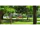Community playground featuring slides and swings amid green lawns and mature trees at 3493 Kings Rd # 106, Palm Harbor, FL 34685