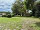 Large grassy backyard with mature trees provides ample outdoor space at 3575 Lake Highland Dr, Palm Harbor, FL 34683