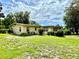 Side and back view of house with spacious green backyard and blue sky at 3575 Lake Highland Dr, Palm Harbor, FL 34683
