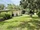 Side view of property showing large grassy area surrounded by lush landscaping at 3575 Lake Highland Dr, Palm Harbor, FL 34683