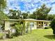 Backyard view showing mature trees surrounding the house at 3575 Lake Highland Dr, Palm Harbor, FL 34683