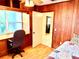 Bedroom with a desk and wood-paneled walls, offering a cozy and functional space at 3575 Lake Highland Dr, Palm Harbor, FL 34683