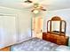 Comfortable bedroom with ceiling fan, closet, and wood dresser with ornate mirror at 3575 Lake Highland Dr, Palm Harbor, FL 34683