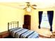 Well-lit bedroom features a ceiling fan, built-in shelving, and window with blue curtains at 3575 Lake Highland Dr, Palm Harbor, FL 34683