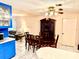 An open-concept dining area features a table and chairs, a china cabinet, and bright white tile flooring at 3575 Lake Highland Dr, Palm Harbor, FL 34683