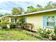 Charming single-story home displaying light blue shutters, complemented by lush, well-maintained landscaping at 3575 Lake Highland Dr, Palm Harbor, FL 34683