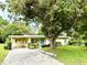 Charming single-story home featuring a brick driveway and mature tree, with a cheerful, light blue door at 3575 Lake Highland Dr, Palm Harbor, FL 34683
