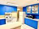 Bright kitchen with blue cabinetry, tiled countertops, and modern appliances at 3575 Lake Highland Dr, Palm Harbor, FL 34683