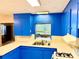 Galley kitchen featuring bright blue cabinetry, stainless steel sink, and tiled countertops at 3575 Lake Highland Dr, Palm Harbor, FL 34683