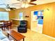 A cozy living room with wood paneled walls and a view into the kitchen at 3575 Lake Highland Dr, Palm Harbor, FL 34683