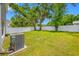 Lush backyard featuring green grass, shade trees and a white vinyl fence for privacy at 36652 N Spanish Rose Dr, Dade City, FL 33525