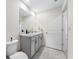 Bright bathroom features double vanity with white cabinets, gray countertop, and modern fixtures at 36652 N Spanish Rose Dr, Dade City, FL 33525