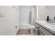 Bright bathroom features a tub with white tile, white fixtures, and gray countertop at 36652 N Spanish Rose Dr, Dade City, FL 33525