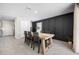 Dining room with a wooden table, decorative black accent wall and neutral finishes at 36652 N Spanish Rose Dr, Dade City, FL 33525