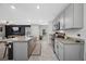Open-concept kitchen featuring gray cabinets, granite countertops, and an island with bar seating at 36652 N Spanish Rose Dr, Dade City, FL 33525