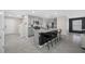 Open-concept kitchen with gray cabinets, granite countertops, and a large center island with barstools at 36652 N Spanish Rose Dr, Dade City, FL 33525