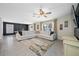 Spacious living room with large sectional sofa, ceiling fan, and neutral color palette at 36652 N Spanish Rose Dr, Dade City, FL 33525