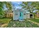 Backyard featuring a storage shed with blue door, offering additional storage space at 3714 N Garrison St, Tampa, FL 33619