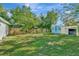Large grassy backyard featuring a storage shed with a matching blue door and a privacy fence at 3714 N Garrison St, Tampa, FL 33619