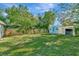 Spacious grassy backyard with storage shed with blue door and privacy fence, perfect for outdoor activities at 3714 N Garrison St, Tampa, FL 33619