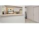 Kitchen passthrough featuring white cabinets, light counters, modern appliances, and eat-in breakfast bar at 3714 N Garrison St, Tampa, FL 33619